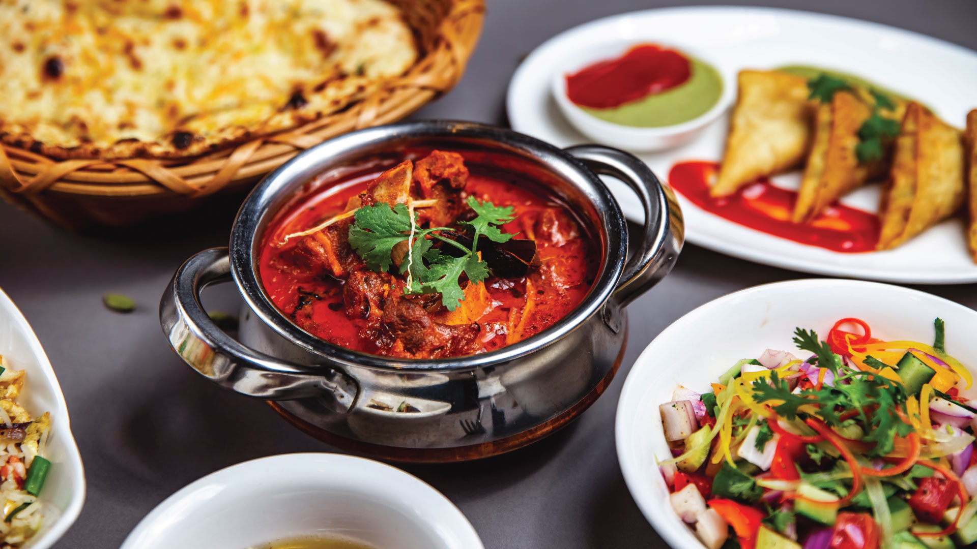 Indian cuisine spread with curry, naan, samosas and salad at Walton Spice