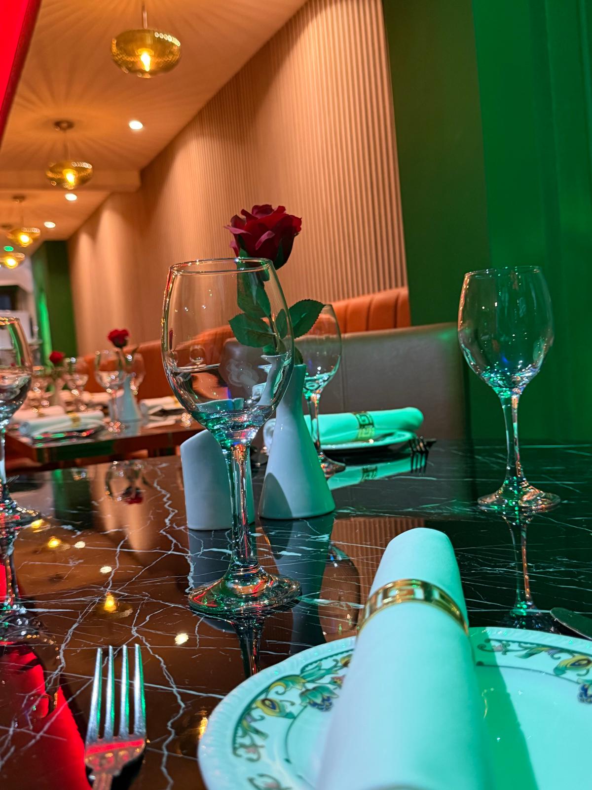 Set dining table with gold napkin rings and red roses at Walton Spice